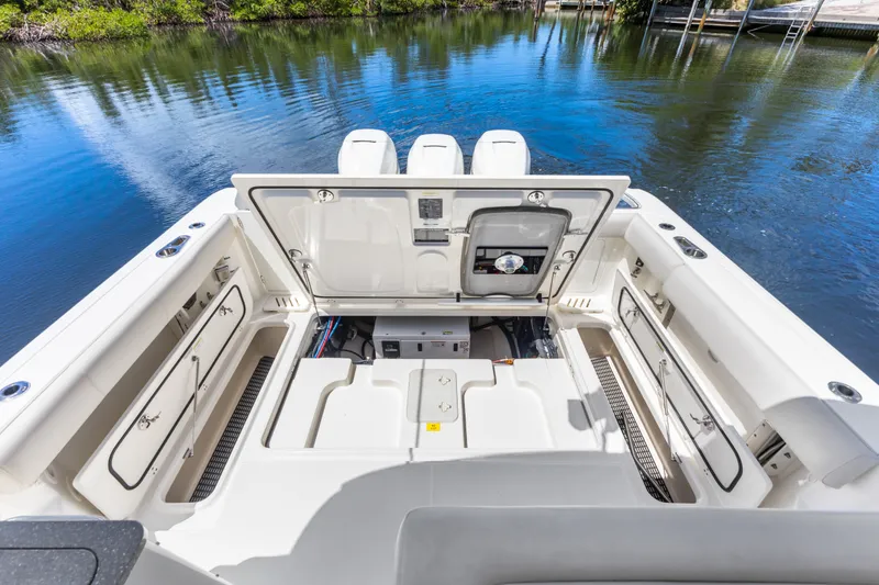 Slide: The Image of 2018 Boston Whaler 345 Conquest boat interior with open storage compartments by the water. - 28