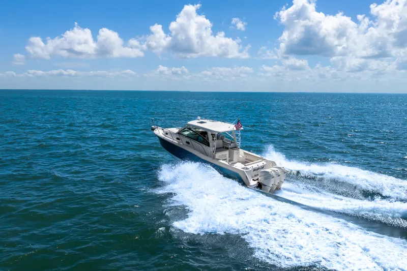 Slide: The Image of 2018 Boston Whaler 345 Conquest cruising on open ocean under blue sky. - 13