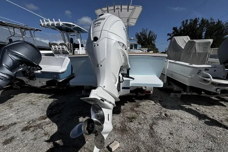 Slide: The Image of 1982 Grady-White Tournament 22 boat with powerful outboard motor, parked on gravel. - 4