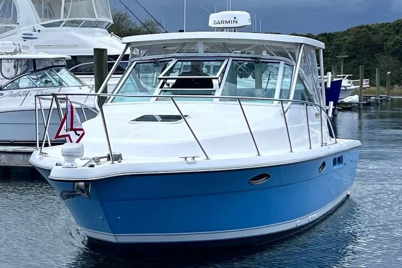 The Image of 2006 Tiara Yachts 2900 Open Classic boat docked in marina, featuring blue hull. - 0