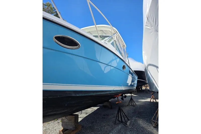 Slide: The Image of 2006 Tiara Yachts 2900 Open Classic, blue hull, on stands under clear sky. - 38