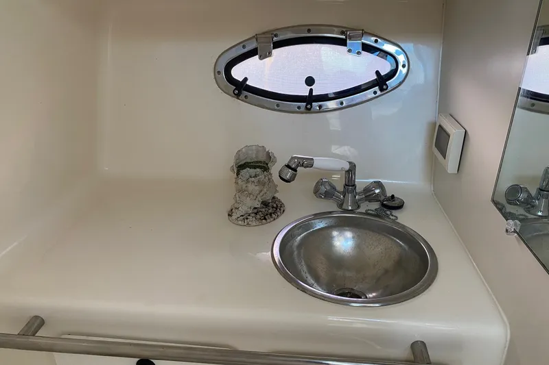 Slide: The Image of 2006 Tiara Yachts 2900 Open Classic bathroom sink with oval porthole and faucet. - 31