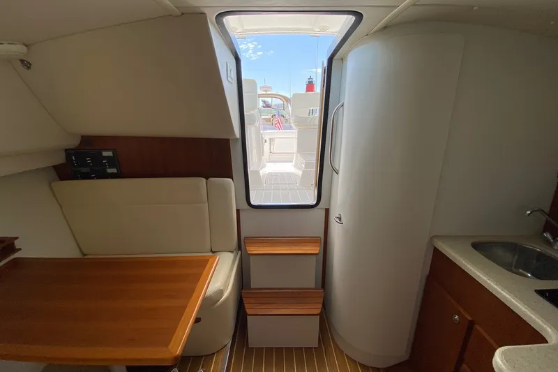 Slide: The Image of Interior of 2006 Tiara Yachts 2900 Open Classic, featuring seating, table, and kitchenette. - 27