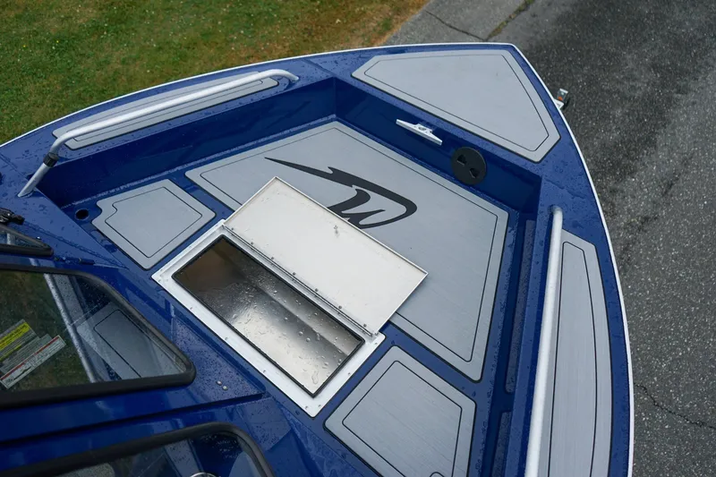 Slide: The Image of 2027 Weldcraft 180 Rebel boat deck with storage compartment, sleek design, and blue-gray color scheme. - 21