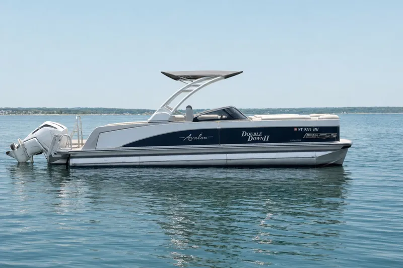 Slide: The Image of 2022 Avalon Catalina Platinum boat on calm water, featuring a versatile rear bench and windshield. - 1