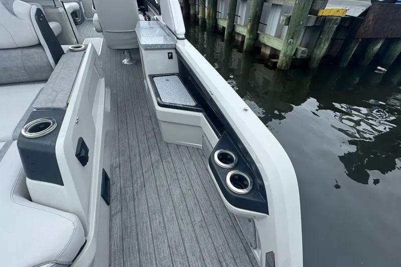 Slide: The Image of 2022 Avalon Catalina Platinum boat interior with versatile rear bench and cup holders by the dock. - 8