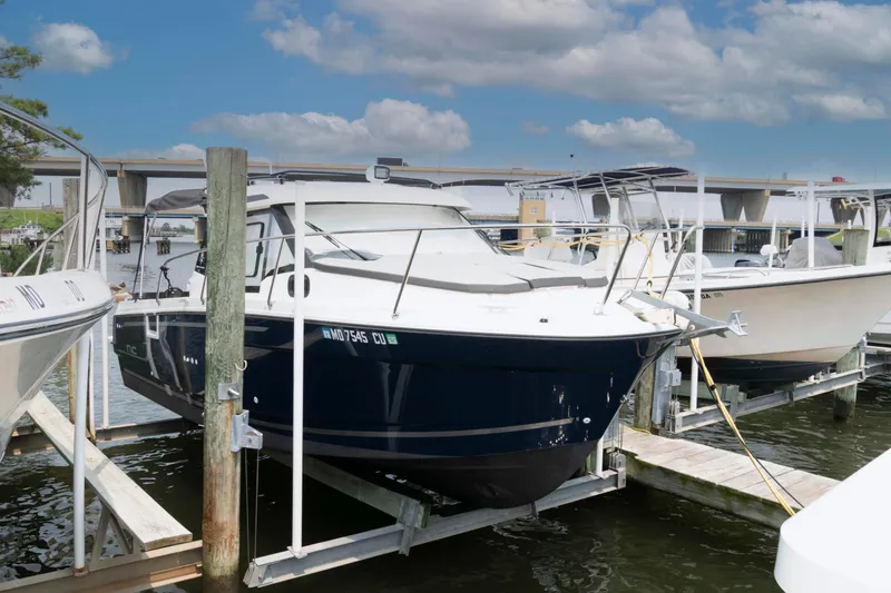 Slide: The Image of 2024 Jeanneau NC 795 Series 2 boat docked at marina under blue sky. - 1