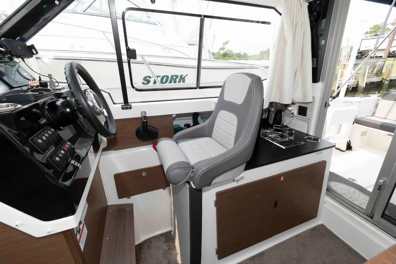 Slide: The Image of Interior of 2024 Jeanneau NC 795 Series 2 boat, featuring helm and seating area. - 12