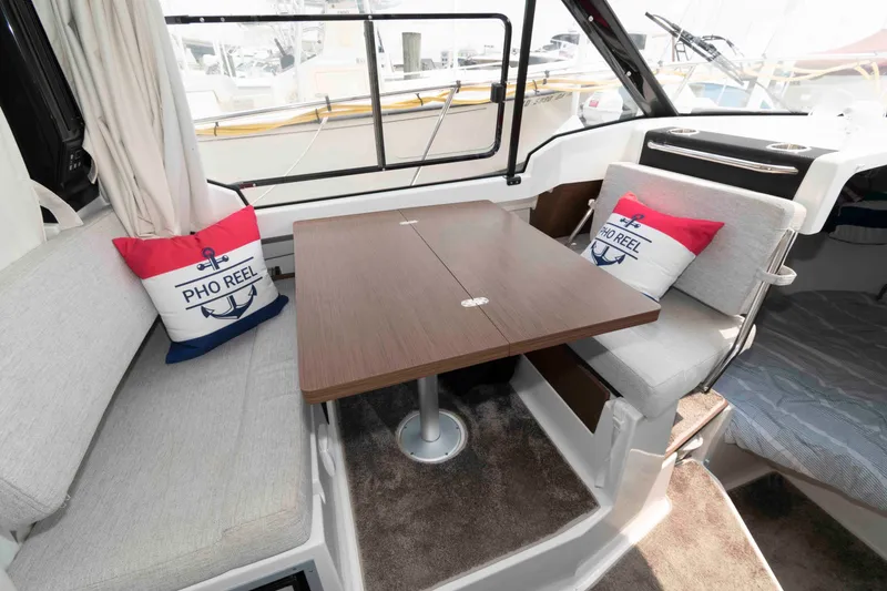 Slide: The Image of Interior of 2024 Jeanneau NC 795 Series 2 boat with cozy seating and nautical-themed pillows. - 10