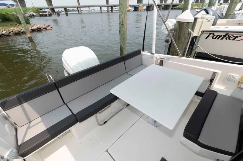 Slide: The Image of 2024 Jeanneau NC 795 Series 2 boat interior with seating and table by the water. - 3