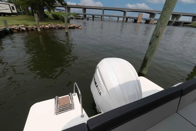 Slide: The Image of 2024 Jeanneau NC 795 Series 2 boat with Yamaha engine docked by a bridge. - 5