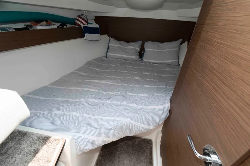 Slide: The Image of Cozy cabin interior of 2024 Jeanneau NC 795 Series 2 with striped bedding. - 15