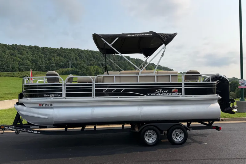 Slide: The Image of 2021 Sun Tracker Fishin' Barge 20 DLX pontoon boat on trailer, scenic background. - 29