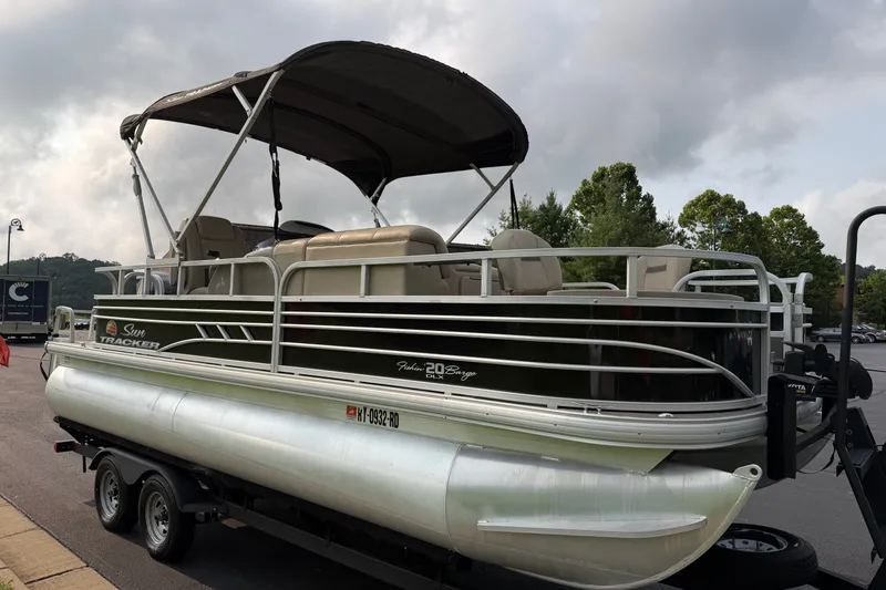 Slide: The Image of 2021 Sun Tracker Fishin' Barge 20 DLX pontoon boat on trailer, parked outdoors. - 35