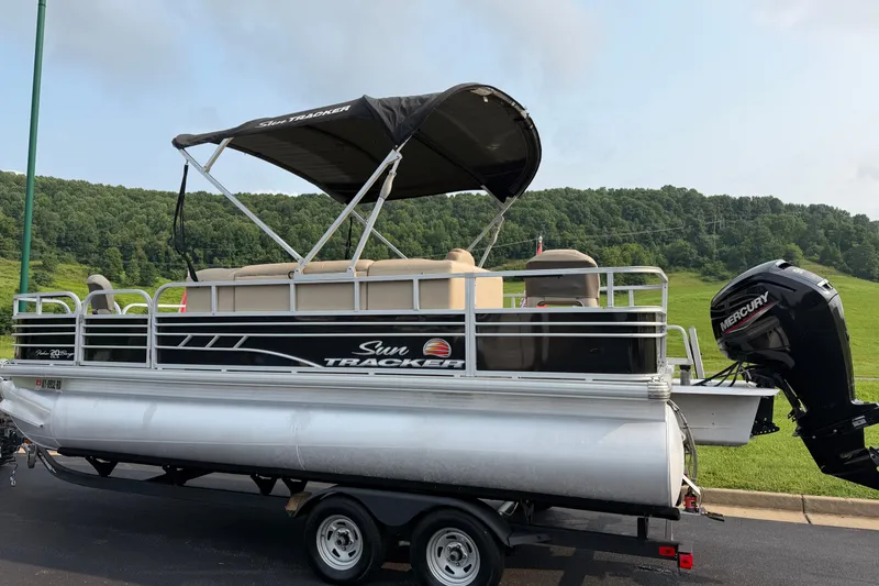 Slide: The Image of 2021 Sun Tracker Fishin' Barge 20 DLX pontoon boat on trailer, scenic background. - 30