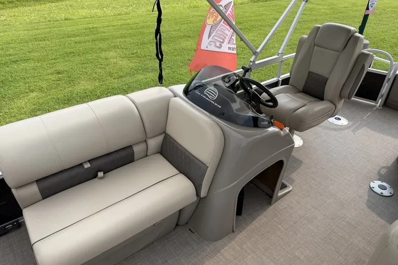 Slide: The Image of 2021 Sun Tracker Fishin' Barge 20 DLX interior with beige seating and steering console. - 9