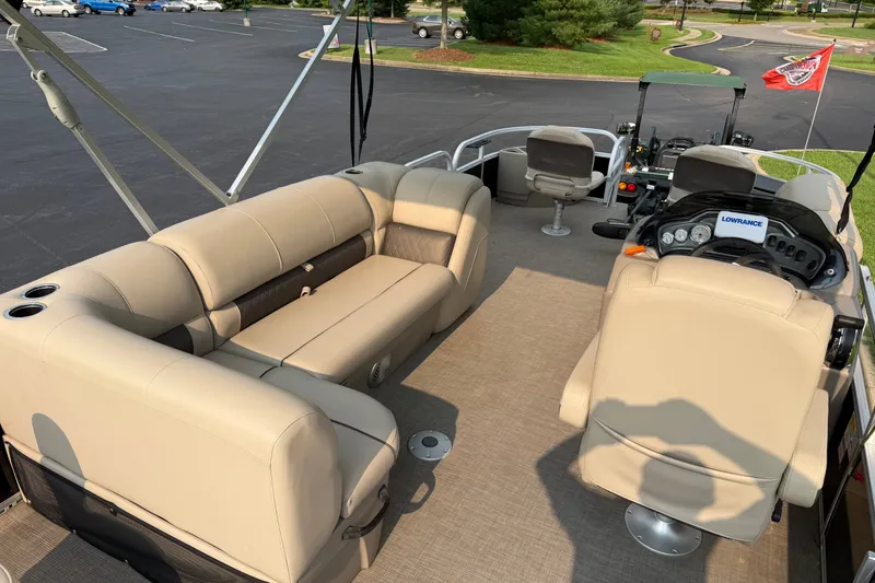 Slide: The Image of 2021 Sun Tracker Fishin' Barge 20 DLX interior with beige seating and control panel. - 26