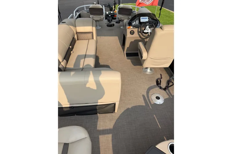 Slide: The Image of 2021 Sun Tracker Fishin' Barge 20 DLX interior with beige seating and steering console. - 21