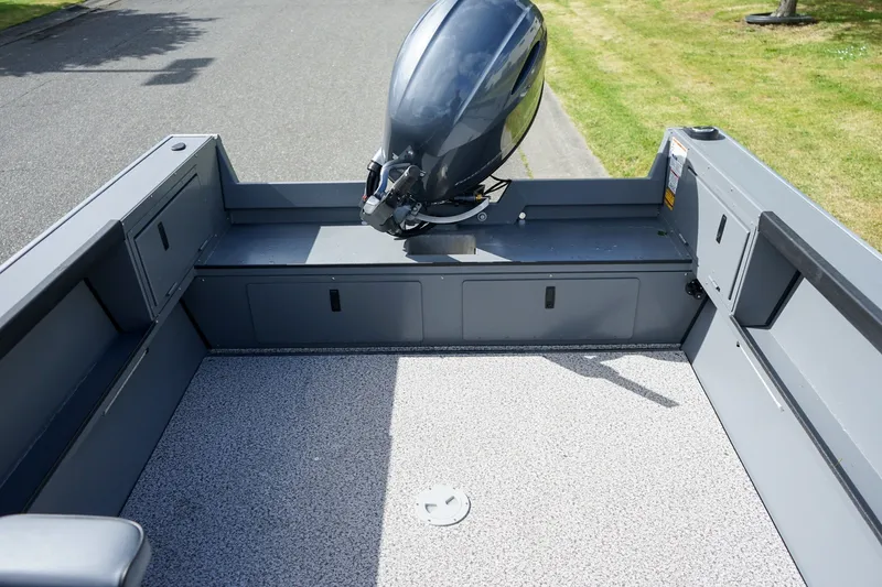 Slide: The Image of 2026 Alumaweld Adventurer 20 boat interior with motor, featuring spacious deck and storage compartments. - 6