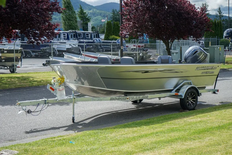 Slide: The Image of 2026 Alumaweld Adventurer 20 boat on trailer, parked outdoors with scenic background. - 16