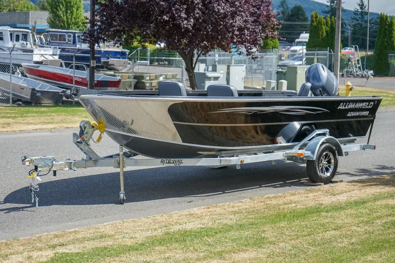 Slide: The Image of 2027 Alumaweld Adventurer 20 boat on trailer, parked outdoors near other boats. - 21