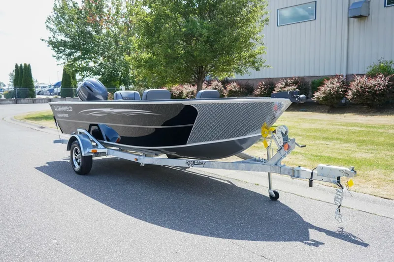 The Image of 2027 Alumaweld Adventurer 20 boat on trailer, parked outdoors near a building. - 1