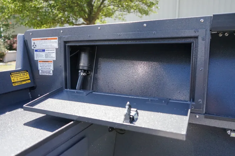 Slide: The Image of 2027 Alumaweld Adventurer 20 boat storage compartment with open hatch and safety labels. - 9