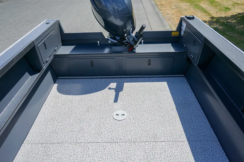 Slide: The Image of 2027 Alumaweld Adventurer 20 boat interior with motor, showcasing spacious deck and storage compartments. - 6