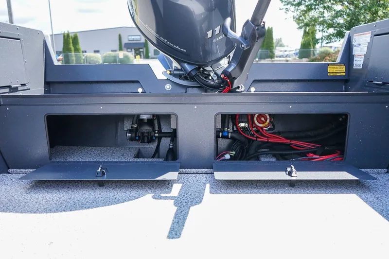 Slide: The Image of 2027 Alumaweld Adventurer 20 boat engine compartment with open storage hatches and visible wiring. - 7