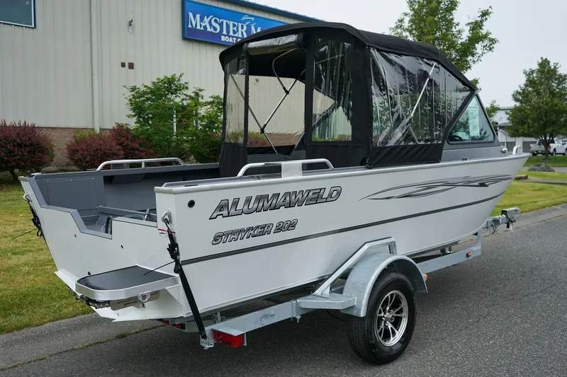 Slide: The Image of 2026 Alumaweld Stryker Sport 202 boat on trailer, parked outdoors near a building. - 3