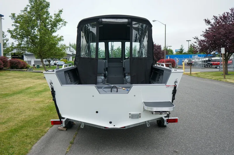 Slide: The Image of 2026 Alumaweld Stryker Sport 202 boat, rear view with canopy, parked on a street. - 4