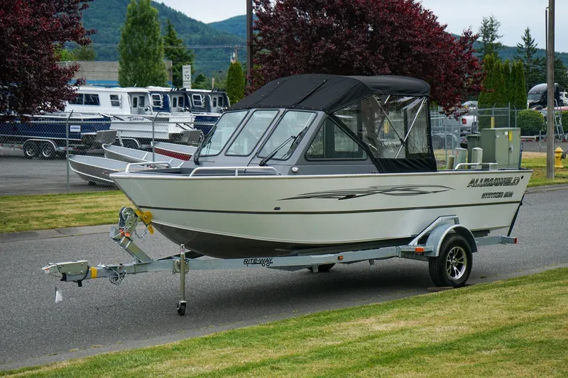 Slide: The Image of 2026 Alumaweld Stryker Sport 202 boat on trailer, parked outdoors. - 17