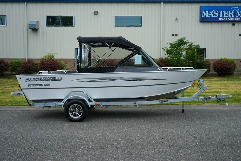 Slide: The Image of 2026 Alumaweld Stryker Sport 202 boat on trailer, parked outside Master Marine Boat Center. - 2