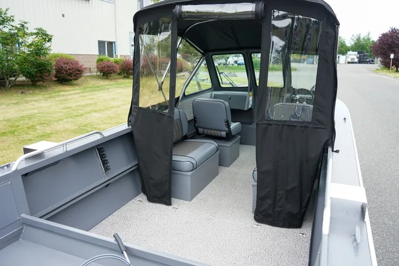 Slide: The Image of 2026 Alumaweld Stryker Sport 202 boat interior with seating and canopy, parked outdoors. - 5