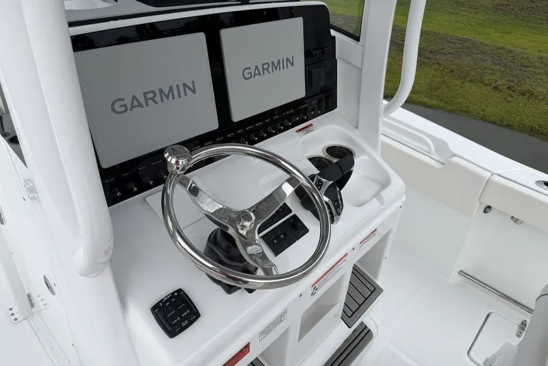 Slide: The Image of 2027 Sea Hunt Ultra 265 SE boat helm with dual Garmin displays and steering wheel. - 18