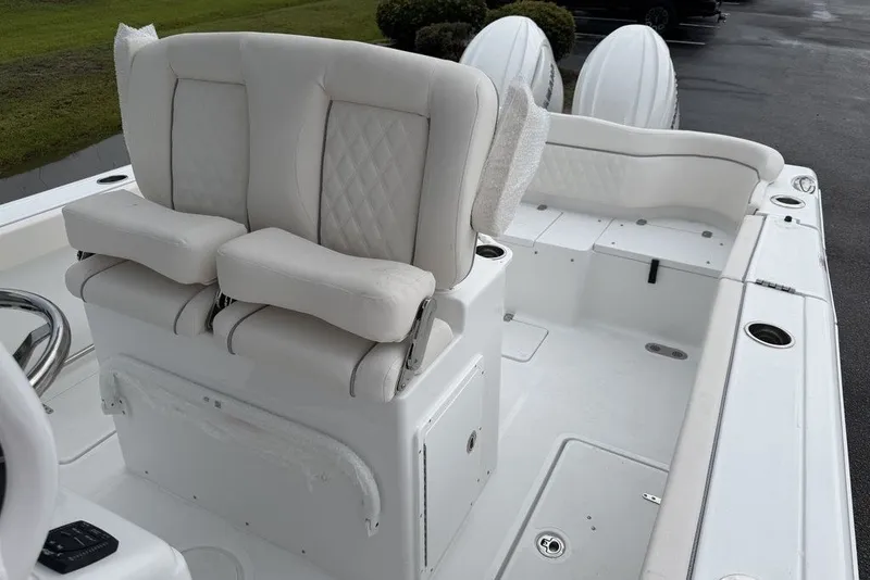 Slide: The Image of 2027 Sea Hunt Ultra 265 SE boat interior with plush white seating and dual engines. - 17