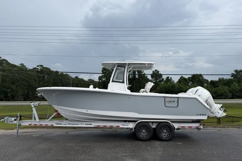 The Image of 2027 Sea Hunt Ultra 265 SE boat on trailer, parked outdoors under cloudy sky. - 0