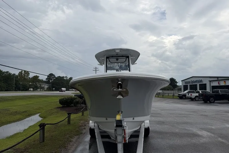 Slide: The Image of 2027 Sea Hunt Ultra 265 SE boat on trailer, parked near showroom under cloudy sky. - 4