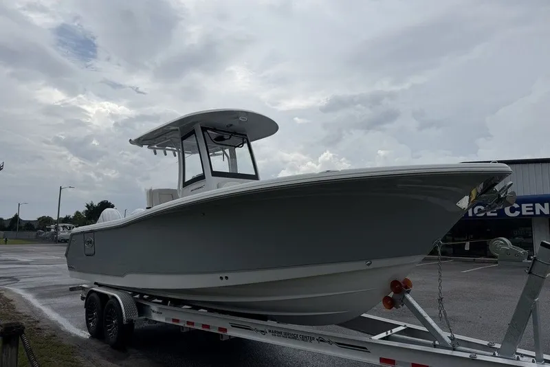 Slide: The Image of 2027 Sea Hunt Ultra 265 SE boat on trailer under cloudy sky. - 8