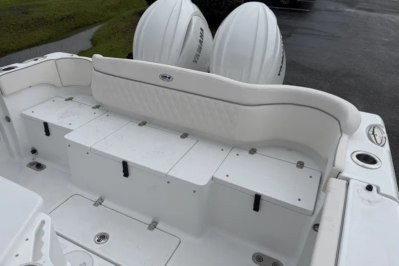 Slide: The Image of 2027 Sea Hunt Ultra 265 SE boat interior with white seating and storage compartments. - 10