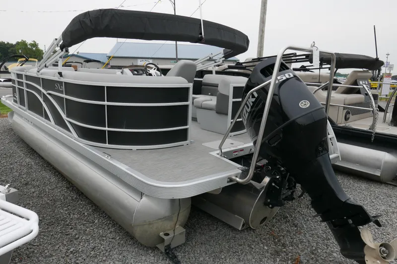 Slide: The Image of 2023 Bennington 21 SXSRC pontoon boat with Suzuki outboard motor, displayed on gravel. - 2