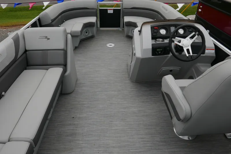 Slide: The Image of 2023 Bennington 21 SXSRC pontoon boat interior with gray seating and steering console. - 13