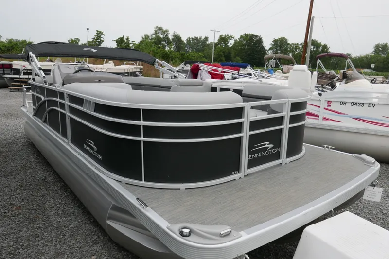Slide: The Image of 2023 Bennington 21 SXSRC pontoon boat displayed in a marina setting. - 1