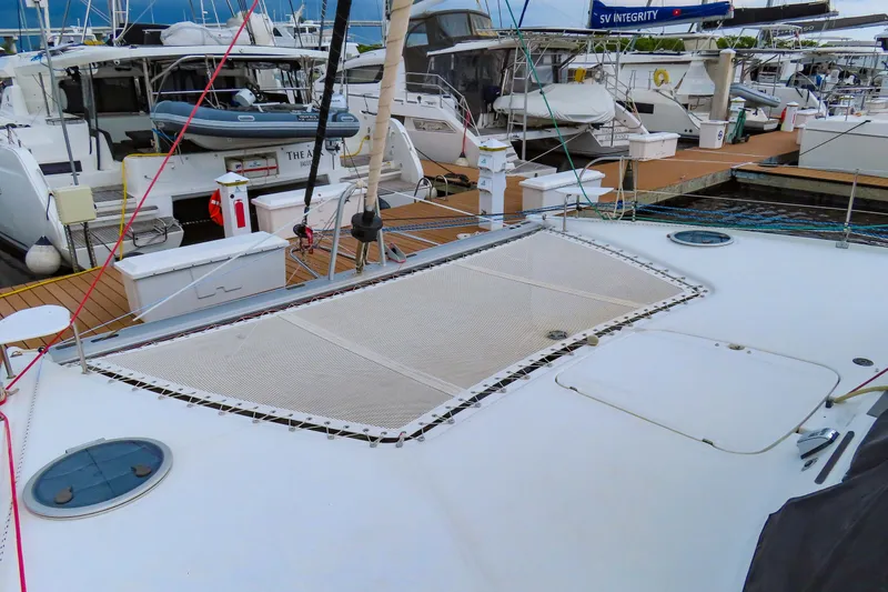 Slide: The Image of 2010 Fountaine Pajot Lipari 41 catamaran docked at marina, showcasing deck and netting. - 4