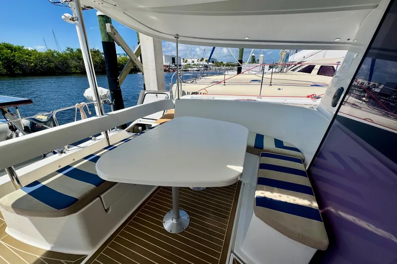Slide: The Image of Outdoor seating area on a 2010 Fountaine Pajot Lipari 41 catamaran, docked by the water. - 10
