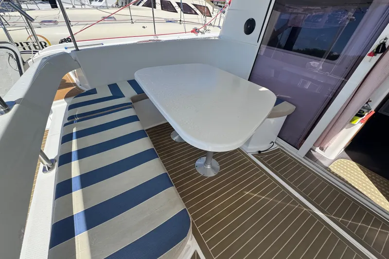 Slide: The Image of Outdoor seating area on a 2010 Fountaine Pajot Lipari 41 catamaran with striped cushions. - 9
