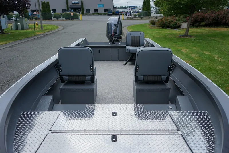 Slide: The Image of 2026 Alumaweld Super Vee 20 boat interior with seating and motor, parked outdoors. - 18
