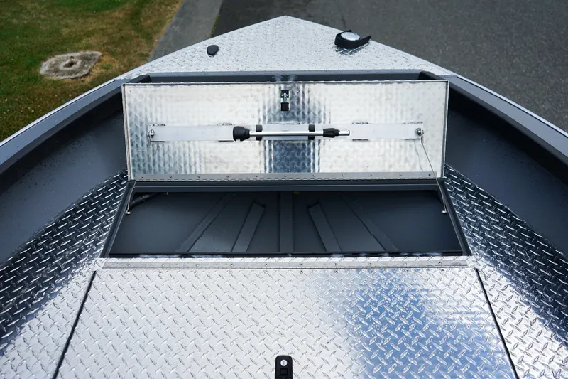 Slide: The Image of 2026 Alumaweld Super Vee 20 boat with open storage compartment and diamond plate flooring. - 16