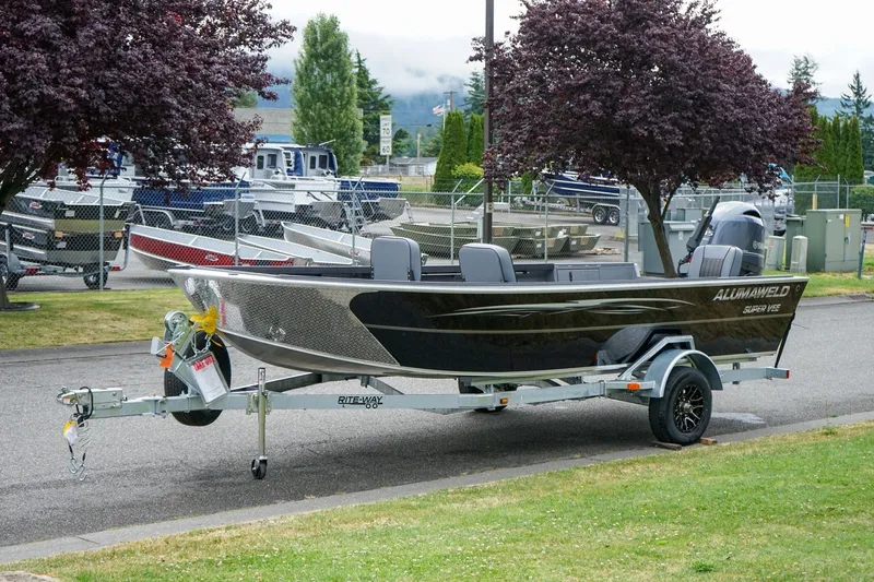 Slide: The Image of 2026 Alumaweld Super Vee 20 boat on trailer, parked outdoors near trees. - 19