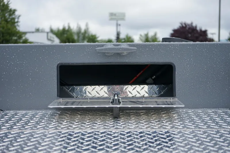 Slide: The Image of 2026 Alumaweld Super Vee 20 boat with diamond plate storage compartment, wet from rain. - 17